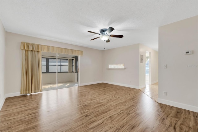 spare room with a textured ceiling, light hardwood / wood-style floors, and ceiling fan