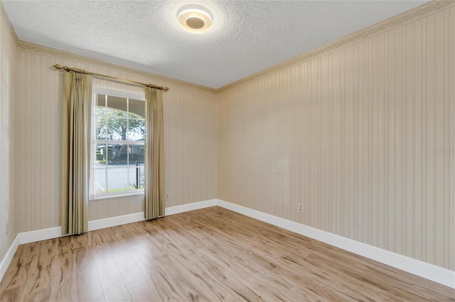 empty room with hardwood / wood-style floors and a textured ceiling