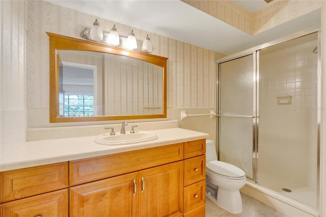 bathroom with vanity, toilet, tile patterned floors, and a shower with door