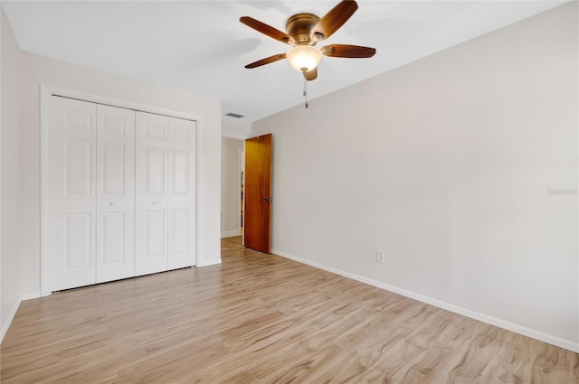 unfurnished bedroom featuring light hardwood / wood-style flooring, a closet, and ceiling fan