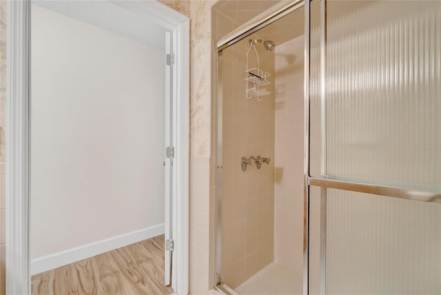 bathroom with hardwood / wood-style floors and walk in shower