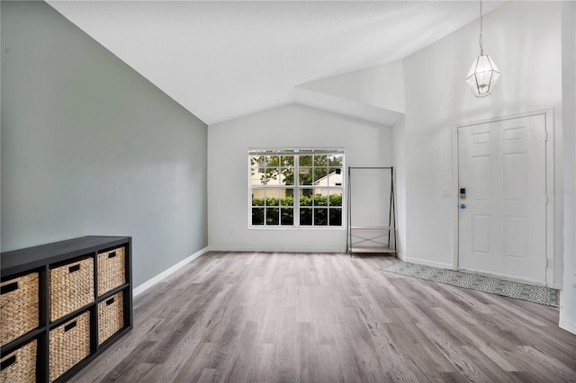 entrance foyer featuring light hardwood / wood-style floors, an inviting chandelier, and vaulted ceiling