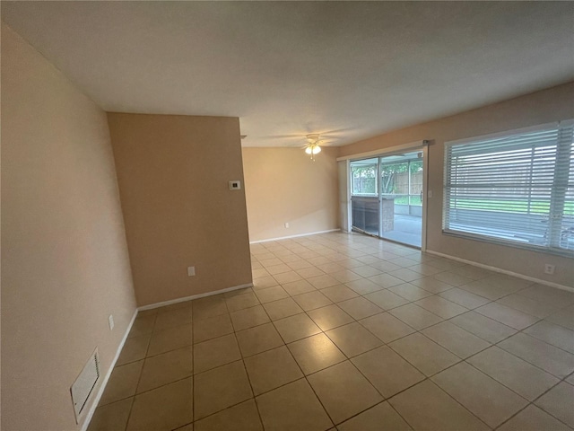 tiled spare room with ceiling fan