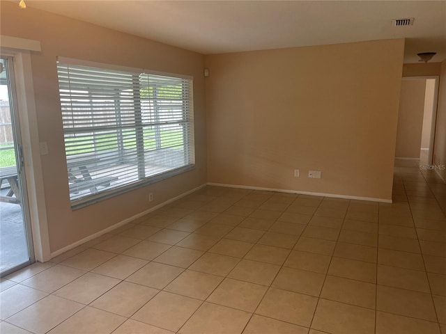 tiled spare room featuring plenty of natural light