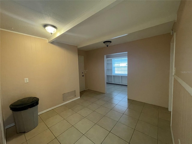 spare room featuring wood walls and light tile patterned floors