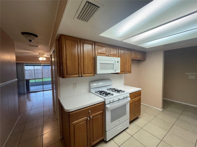 kitchen featuring white appliances, ceiling fan, and light tile patterned flooring