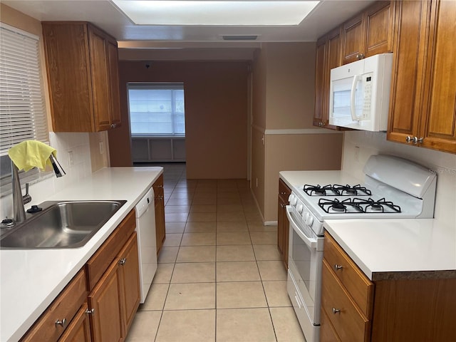 kitchen with decorative backsplash, white appliances, sink, and light tile patterned floors