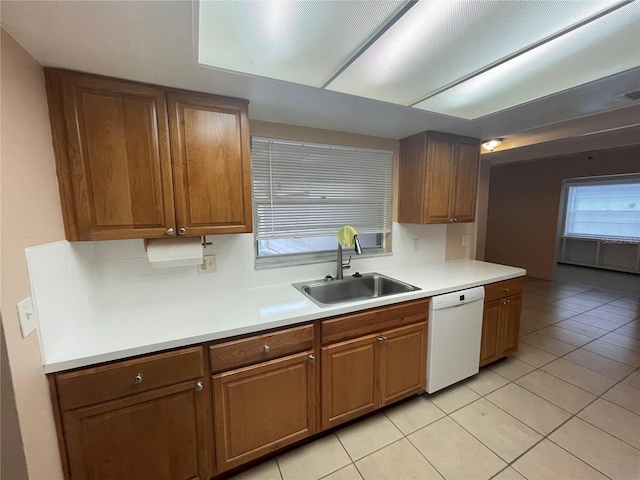 kitchen with dishwasher, light tile patterned floors, and sink