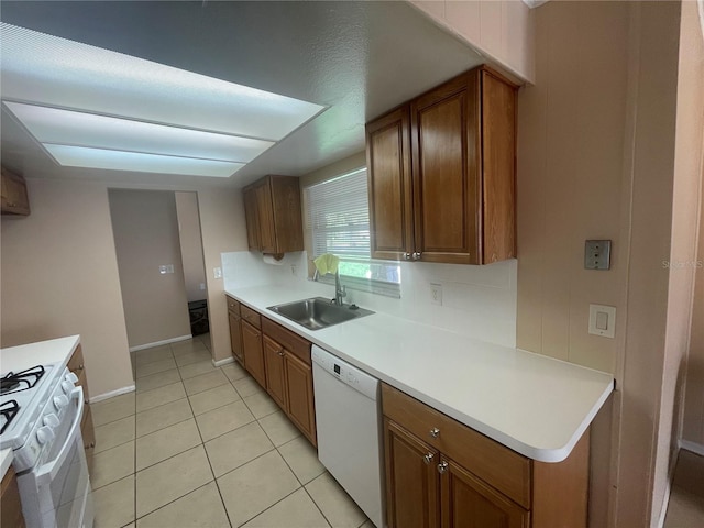 kitchen featuring white appliances, sink, and light tile patterned floors