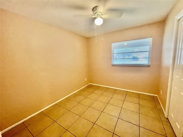 tiled empty room with ceiling fan