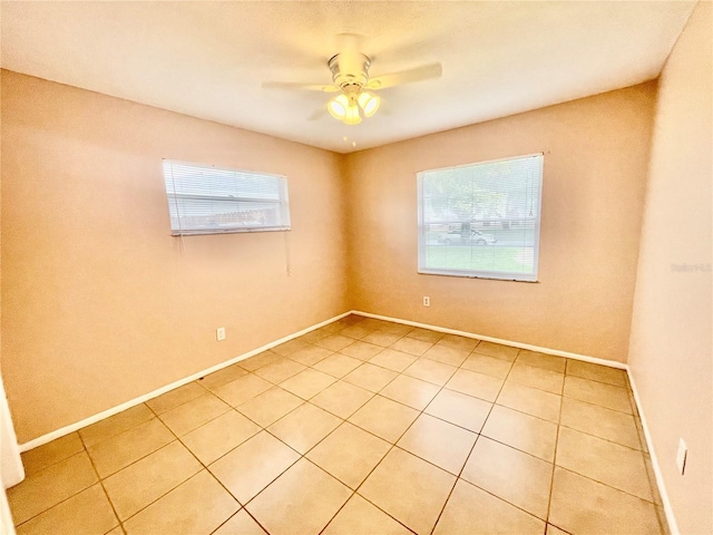 empty room with ceiling fan and light tile patterned flooring