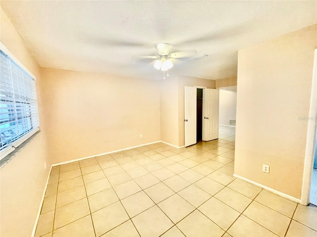 unfurnished room featuring ceiling fan, a textured ceiling, and light tile patterned flooring