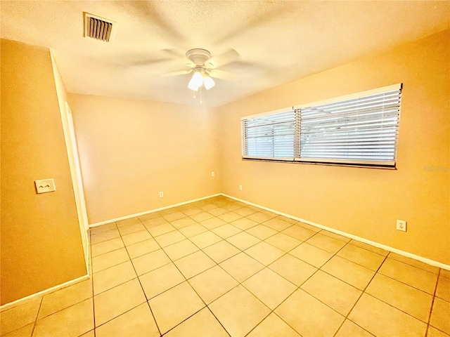 tiled empty room featuring a textured ceiling and ceiling fan