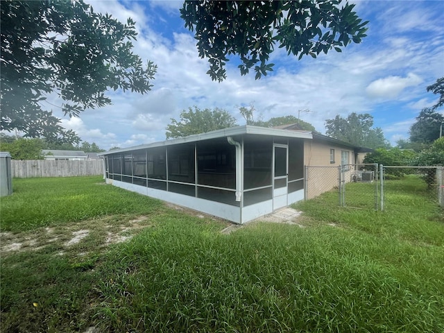 back of house with a sunroom and a lawn