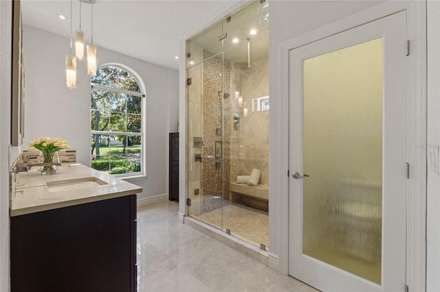 bathroom featuring an enclosed shower, vanity, and a chandelier