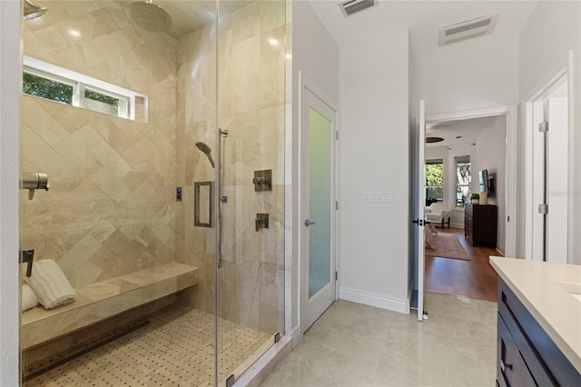 bathroom featuring a shower with shower door and vanity