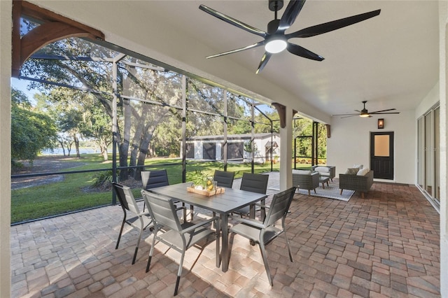 view of patio featuring an outdoor hangout area, ceiling fan, and glass enclosure