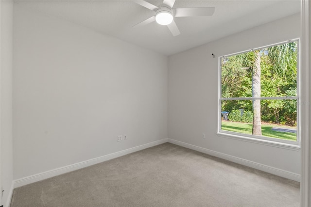 spare room with ceiling fan and light colored carpet