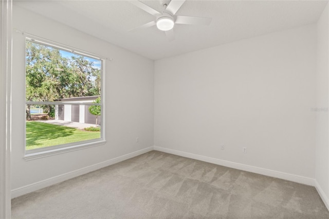 carpeted spare room with ceiling fan