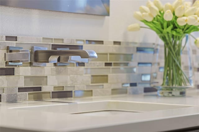 room details featuring sink and decorative backsplash