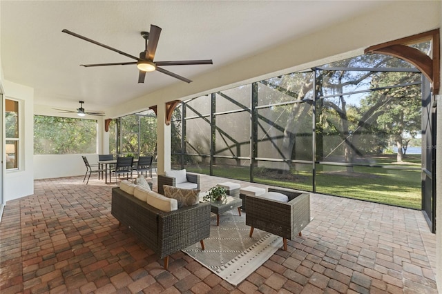 view of patio / terrace with an outdoor hangout area, ceiling fan, and glass enclosure