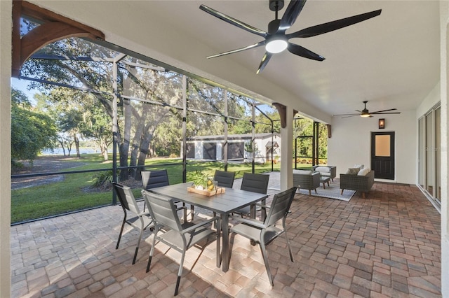 sunroom / solarium with a lawn, outdoor lounge area, a patio, and ceiling fan