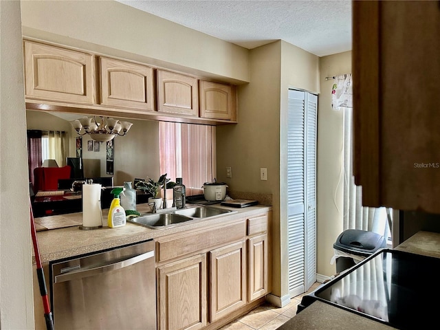 kitchen featuring light brown cabinetry, sink, dishwasher, and a textured ceiling