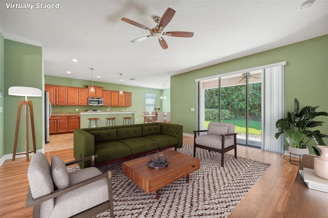 living room with light wood-type flooring and a textured ceiling