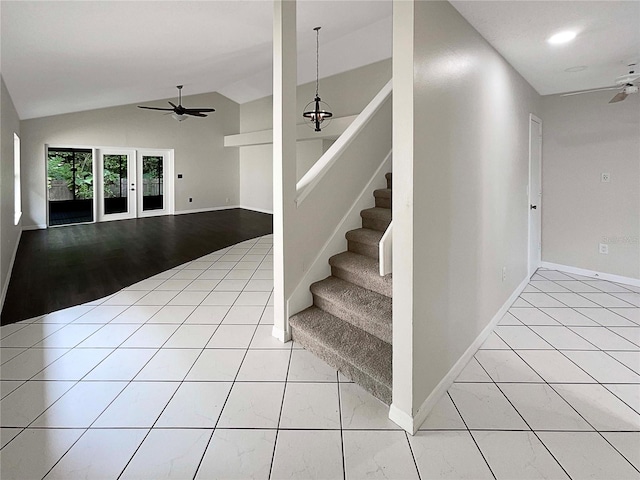 staircase with ceiling fan with notable chandelier, lofted ceiling, and hardwood / wood-style floors