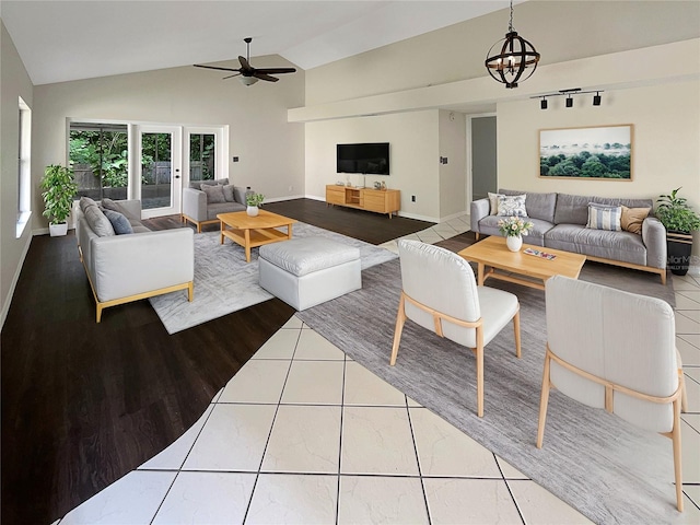 living room featuring ceiling fan with notable chandelier, lofted ceiling, and wood-type flooring