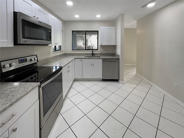 kitchen featuring a textured ceiling, white cabinetry, sink, and stainless steel appliances