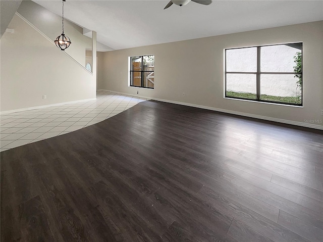 empty room with a healthy amount of sunlight, hardwood / wood-style floors, and ceiling fan