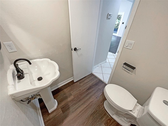 bathroom featuring hardwood / wood-style floors and toilet