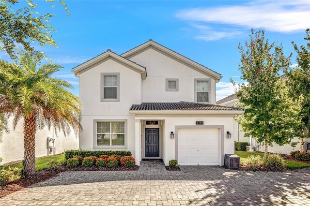 4782 Kings Castle Cir, Kissimmee, FL 34746 - view of front of home with stucco siding, decorative driveway, a tile roof, a garage, and cooling unit