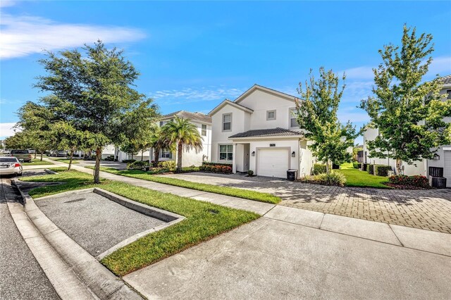 4782 Kings Castle Cir, Kissimmee, FL 34746 - view of front of house featuring stucco siding, an attached garage, decorative driveway, and a front yard