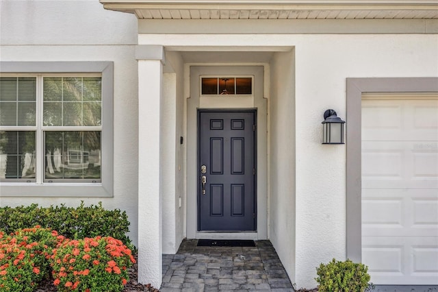 4782 Kings Castle Cir, Kissimmee, FL 34746 - doorway to property with stucco siding and a garage