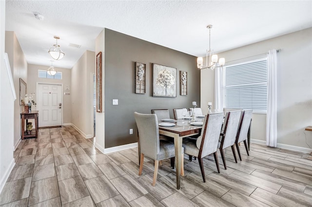 dining space featuring a textured ceiling and a chandelier