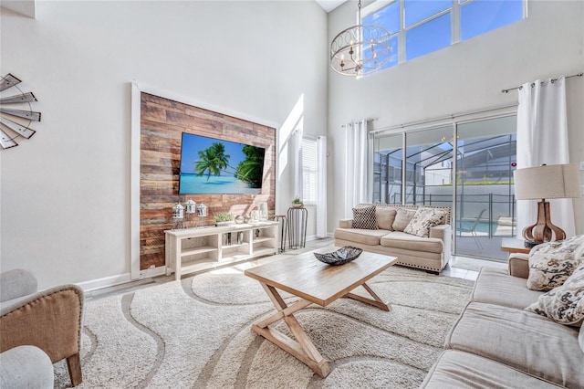 living room with a notable chandelier, a high ceiling, and hardwood / wood-style flooring