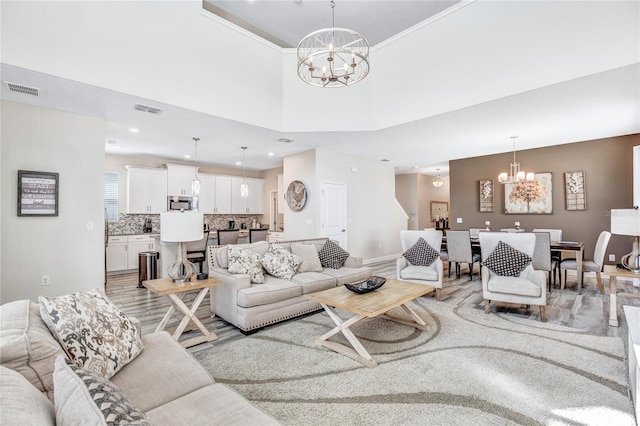 living room with a high ceiling, a chandelier, and hardwood / wood-style flooring