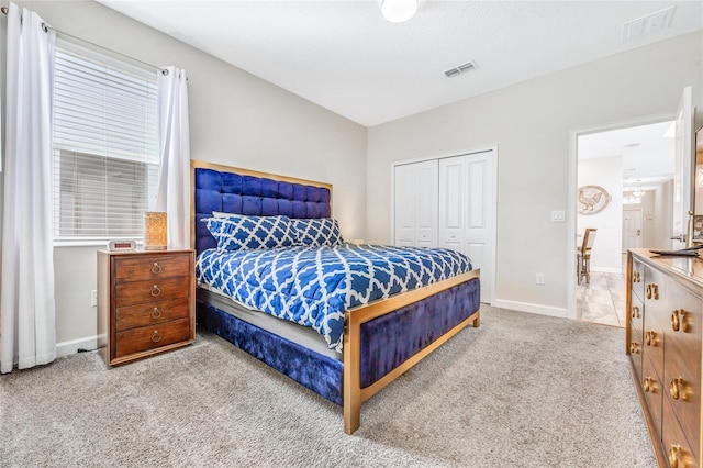 bedroom featuring light carpet and a closet