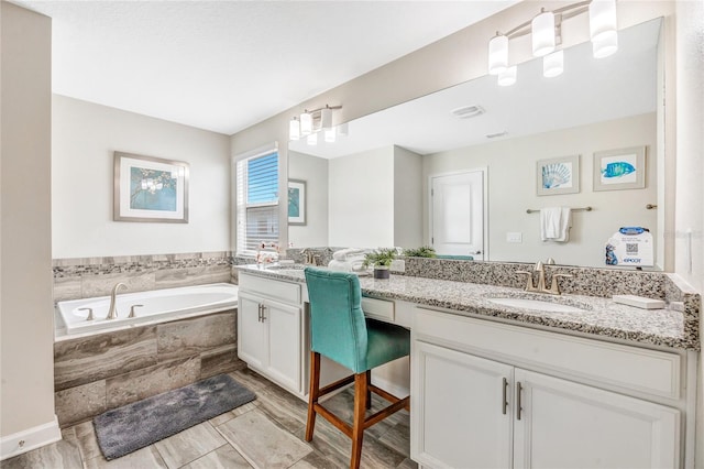 bathroom featuring tiled bath, vanity, and hardwood / wood-style flooring