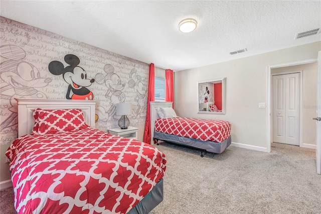 bedroom featuring a textured ceiling and carpet flooring