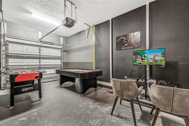 rec room with a textured ceiling and concrete floors