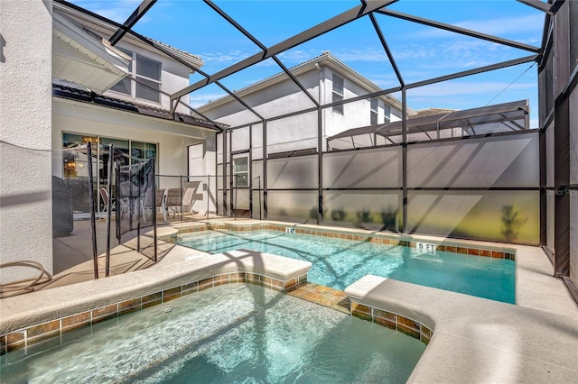 view of swimming pool with a patio, an in ground hot tub, and a lanai