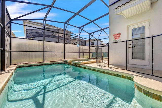 view of swimming pool featuring a patio, glass enclosure, and an in ground hot tub