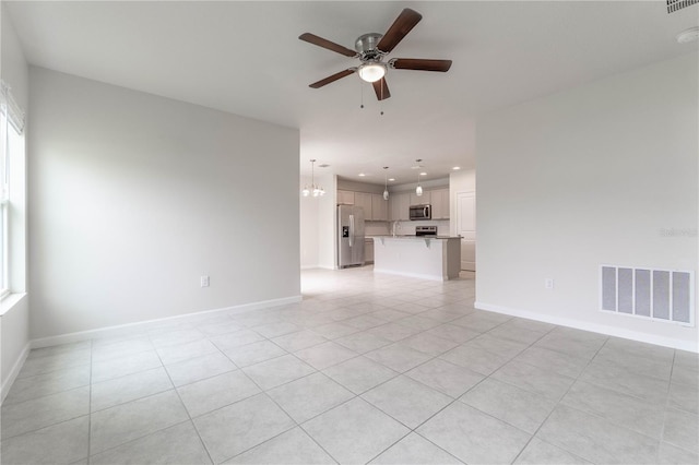 unfurnished living room with sink, light tile patterned floors, and ceiling fan with notable chandelier