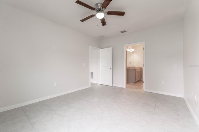 unfurnished bedroom with ensuite bath, light tile patterned floors, and ceiling fan