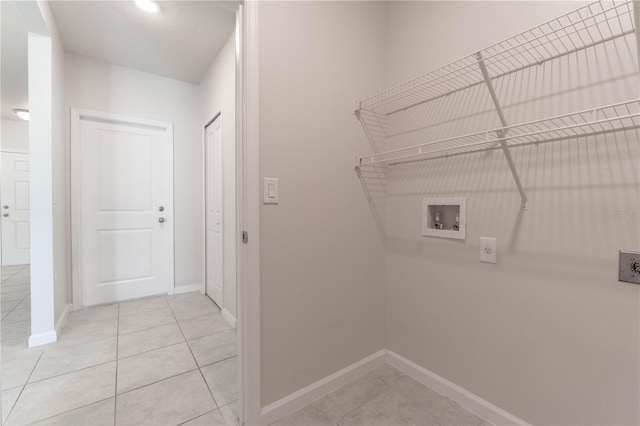 clothes washing area featuring hookup for a washing machine, light tile patterned floors, and hookup for an electric dryer