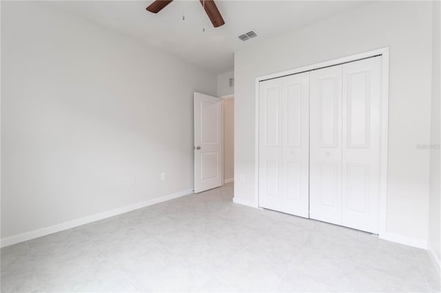 unfurnished bedroom with light tile patterned floors, a closet, and ceiling fan