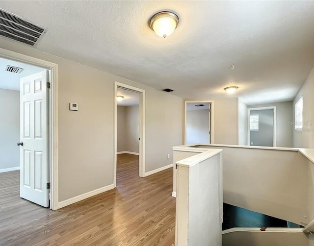 interior space featuring light hardwood / wood-style flooring and a textured ceiling